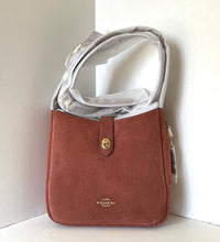 Load image into Gallery viewer, Brown Coach handbag with a clear plastic cover on a white background