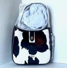 Load image into Gallery viewer, Coach handbag with cow print pattern on a white background
