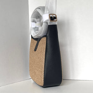 Two-tone handbag with cork and black leather design on a white background