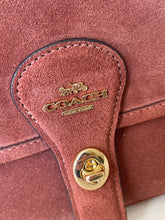 Load image into Gallery viewer, Close-up of a brown leather bag with gold hardware and Coach logo.