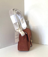 Load image into Gallery viewer, Brown leather handbag with a white strap on a light gray background