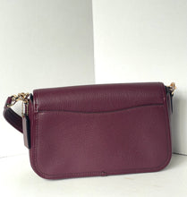 Load image into Gallery viewer, A pebbled leather shoulder bag in a deep plum purple color, featuring a front slip pocket and a dark strap with gold-tone hardware, set against a plain white background.