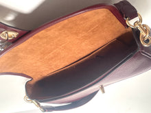 Load image into Gallery viewer, Close-up of a dark burgundy leather handbag showing the interior lining with a tan suede-like insert and gold-tone hardware.