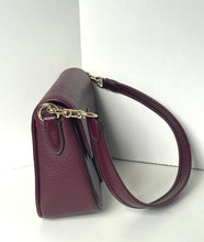 Load image into Gallery viewer, A burgundy pebbled leather shoulder bag with gold-tone hardware, shown from a side profile view against a white studio background.