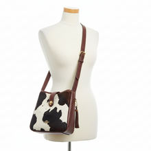 Load image into Gallery viewer, Handbag with cow print design on a mannequin against a white background