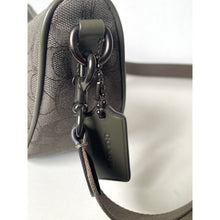 Load image into Gallery viewer, Close-up of a Coach handbag with a silver chain detail on a white background