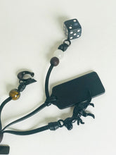 Load image into Gallery viewer, Black phone case with decorative elements including a dice and beads on a white background