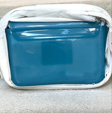Load image into Gallery viewer, Blue pouch with a white border on a beige surface