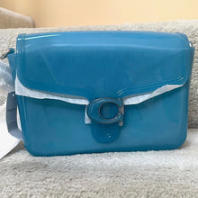 Load image into Gallery viewer, Blue handbag with a silver buckle on a beige surface