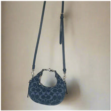 Load image into Gallery viewer, Blue handbag with a strap on a beige background