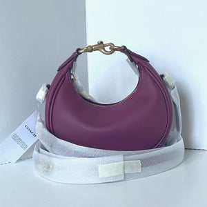 Purple handbag with a matching strap on a white background