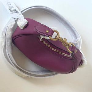 Purple handbag with gold zipper and clasp on a white background
