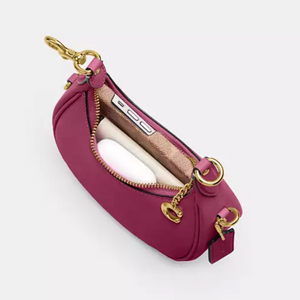 Pink banana-shaped pouch with gold accents on a white background