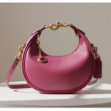 Load image into Gallery viewer, Pink handbag with gold accents on a wooden surface