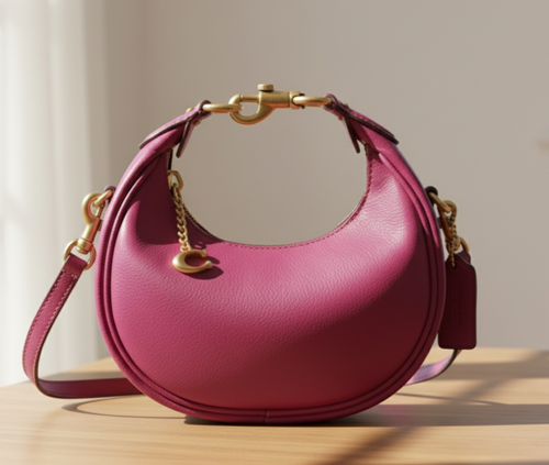 Pink handbag with gold accents on a light gray background