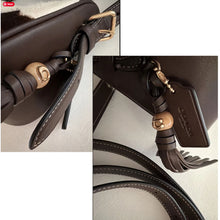 Load image into Gallery viewer, Close-up of a brown leather handbag strap with gold hardware on a light gray background