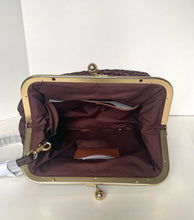Load image into Gallery viewer, An open handbag with a burgundy fabric interior, gold-tone metal frame, and a textured burgundy exterior, shown against a plain white background.