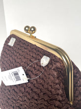 Load image into Gallery viewer, A close-up of a brown woven clutch bag with a gold metal kiss-lock frame and a white product tag attached.
