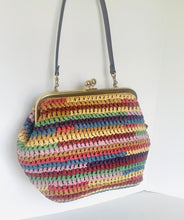 Load image into Gallery viewer, A crocheted handbag with horizontal stripes of multiple colors including yellow, pink, blue, green, and red, featuring a gold-tone metal frame and a dark strap, shown against a plain white background.