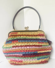 Load image into Gallery viewer, A handmade crocheted handbag with horizontal stripes of multiple colors including pink, yellow, green, blue, and red, featuring a dark gray top handle and a gold-tone kiss-lock clasp.
