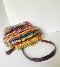 Load image into Gallery viewer, A crocheted handbag with horizontal stripes of multiple colors, featuring a gold-tone metal frame and a dark brown leather strap, set against a plain white background.