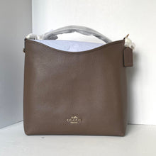 Load image into Gallery viewer, Brown leather handbag with visible brand logo on a white background