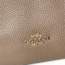 Load image into Gallery viewer, Close-up of a beige leather Coach handbag with gold logo.