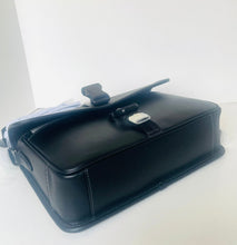 Load image into Gallery viewer, A black leather briefcase or satchel with a silver-toned metal clasp, resting on a white surface against a white background.