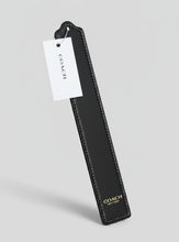 Load image into Gallery viewer, A Coach leather keychain or bookmark in black with white contrast stitching, featuring a white hanging tag with the Coach logo and gold 'COACH NEW YORK' text near the bottom.