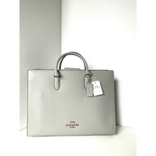 Load image into Gallery viewer, Light gray Coach handbag with a tag on a white background