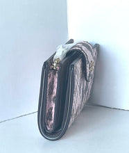 Load image into Gallery viewer, A small shoulder bag with a pink and black snakeskin pattern, black leather trim, and gold-tone hardware, leaning against a white corner wall.