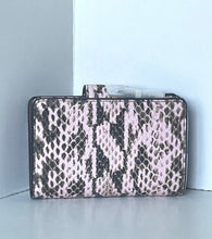Load image into Gallery viewer, A rectangular clutch bag with a pink, black, and gray snakeskin pattern, standing upright on a gray surface against a white wall.