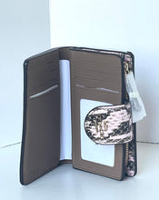 Load image into Gallery viewer, An open brown leather wallet with multiple card slots, a clear ID window, and a small zippered pocket featuring a pink and black snakeskin pattern.