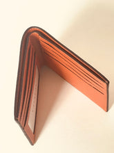 Load image into Gallery viewer, A brown leather bifold wallet shown open, displaying its interior card slots and textured leather lining, set against a plain off-white background.