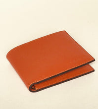 Load image into Gallery viewer, A textured orange-brown leather bifold wallet with visible stitching, shown closed on a plain off-white background.