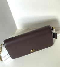 Load image into Gallery viewer, A Coach shoulder bag in dark brown pebbled leather with gold hardware, shown with its white hangtag and dust bag on a white surface.