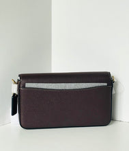 Load image into Gallery viewer, A dark plum purple pebbled leather crossbody bag with a textured gray horizontal stripe across the front flap, displayed on a white surface against a white background.