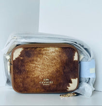 Load image into Gallery viewer, Coach handbag with cow print pattern on a white background