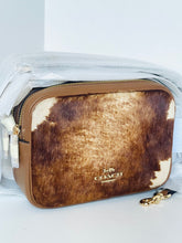 Load image into Gallery viewer, Coach pouch with brown and white cowhide leather design on a light gray background