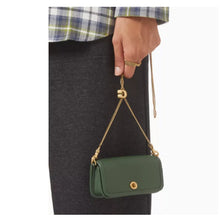 Load image into Gallery viewer, Green handbag with gold chain strap held by a person wearing a plaid shirt.