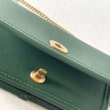 Load image into Gallery viewer, Green handbag with gold accents on a white background
