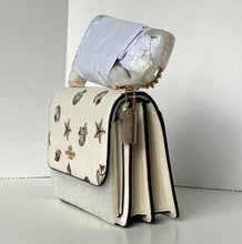 Load image into Gallery viewer, Beige handbag with starfish pattern and gold accents on a white background