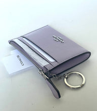 Load image into Gallery viewer, A Coach zippered card holder wallet in light purple leather with a silver-tone logo and keychain ring, shown with its white COACH paper tag on a light gray background.