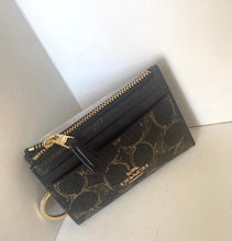 Load image into Gallery viewer, Black wallet with gold accents on a light gray background