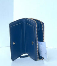 Load image into Gallery viewer, A Coach zip-around wallet in dark navy blue leather, shown open to reveal its interior card slots and gold-tone hardware, with a white Coach hangtag attached.