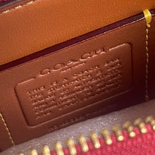 Load image into Gallery viewer, Close-up of a brown leather wallet with gold zipper, featuring a brand logo.