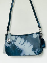 Load image into Gallery viewer, A small shoulder bag with a glossy navy and white tie-dye pattern, featuring a matching navy strap, silver-tone hardware, and a small hanging tag.