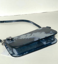 Load image into Gallery viewer, A glossy, dark blue and white tie-dye crossbody bag with a matching strap, resting on a light-colored surface.
