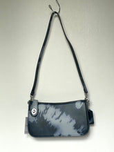 Load image into Gallery viewer, A small shoulder bag with a glossy black and white tie-dye pattern, featuring a black strap and silver hardware, hanging against a plain light gray wall.