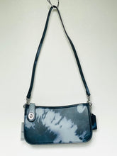 Load image into Gallery viewer, A small crossbody bag with a dark navy and white tie-dye pattern, featuring a matching dark strap and silver-tone hardware, shown against a plain off-white background.